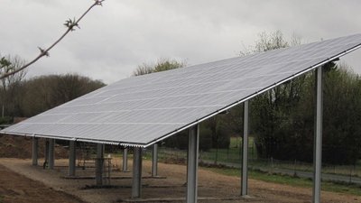 Die Solarpanels sind auf stabilen Stützen montiert und fangen das Licht an einem grauen, bewölkten Tag ein.